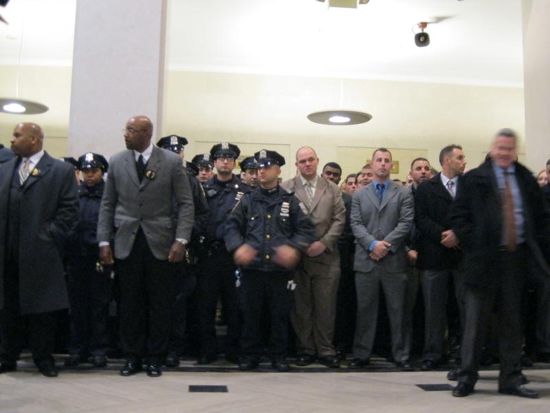 Police officers wait outside the courtoom.